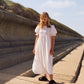 Full length image of minimalist puff sleeve white dress. Perfect for summer. Gathered tiered skirt and puff sleeves