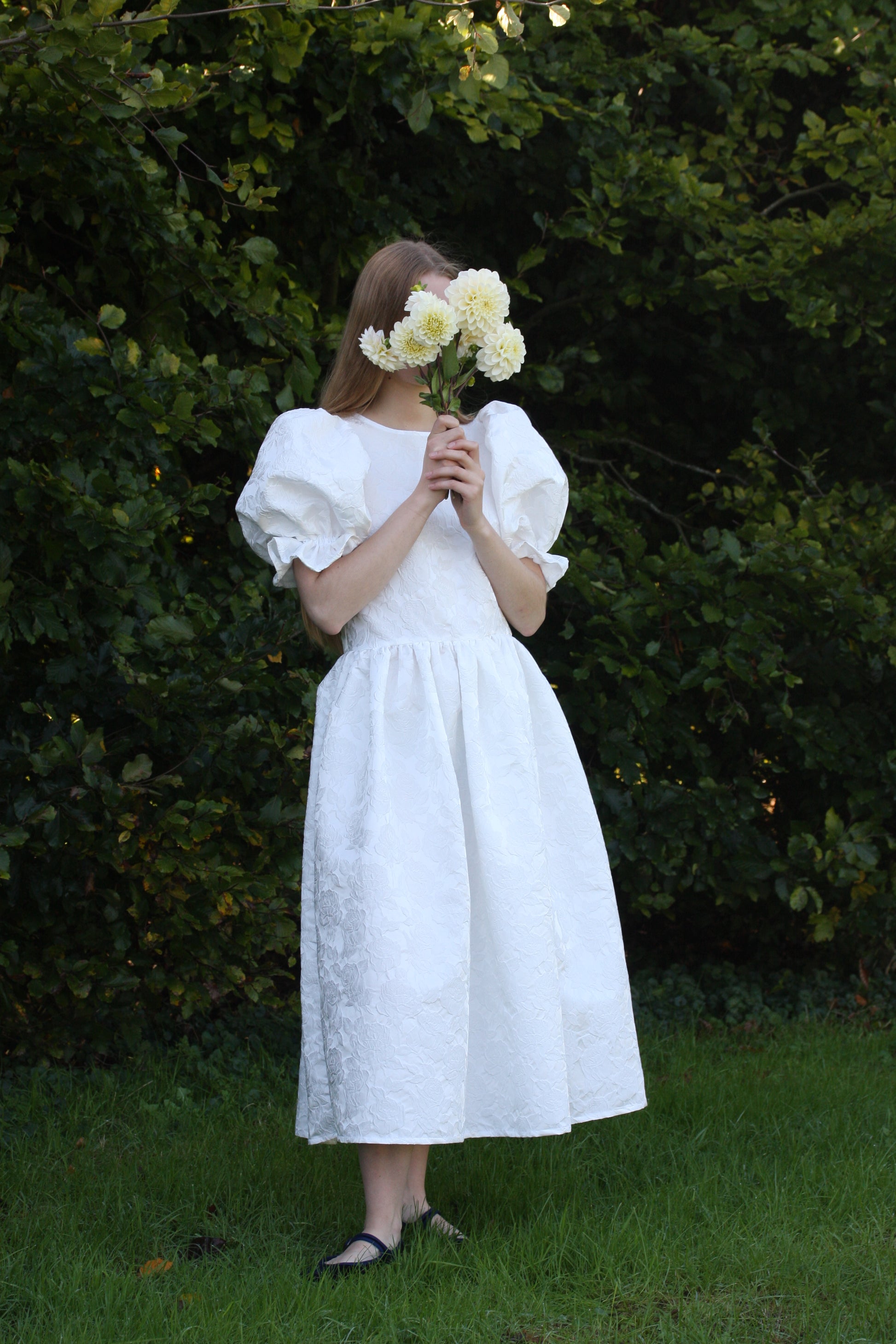 Full length image of white jacquard floral wedding dress with large puff sleeves