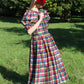 Full length image of long midi length silk dress in red, green and yellow check gingham silk. Designer custom made silk dress