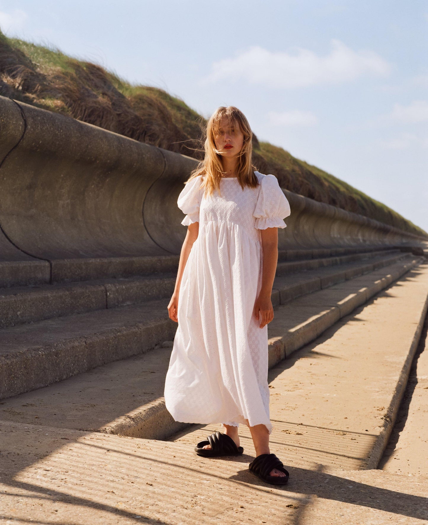 Full length image of minimalist puff sleeve white dress. Perfect for summer. Gathered tiered skirt and puff sleeves