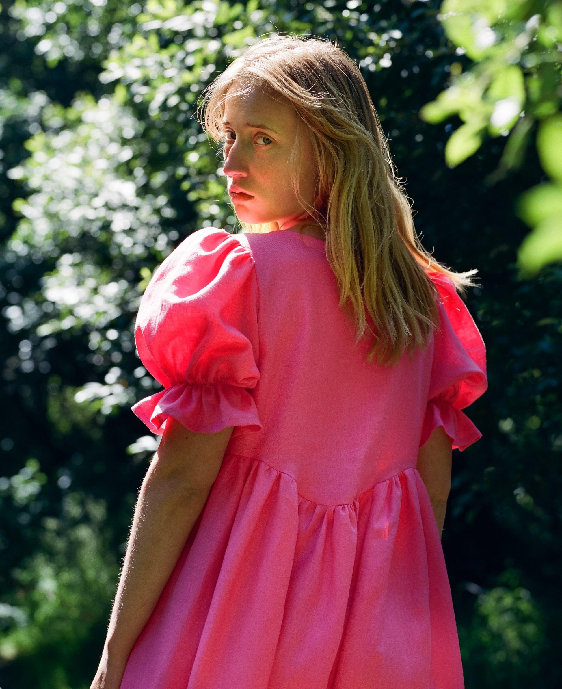 Stunning bright pink dress with puff sleeves and a curved empire seam and tiered hand gathered skirt
